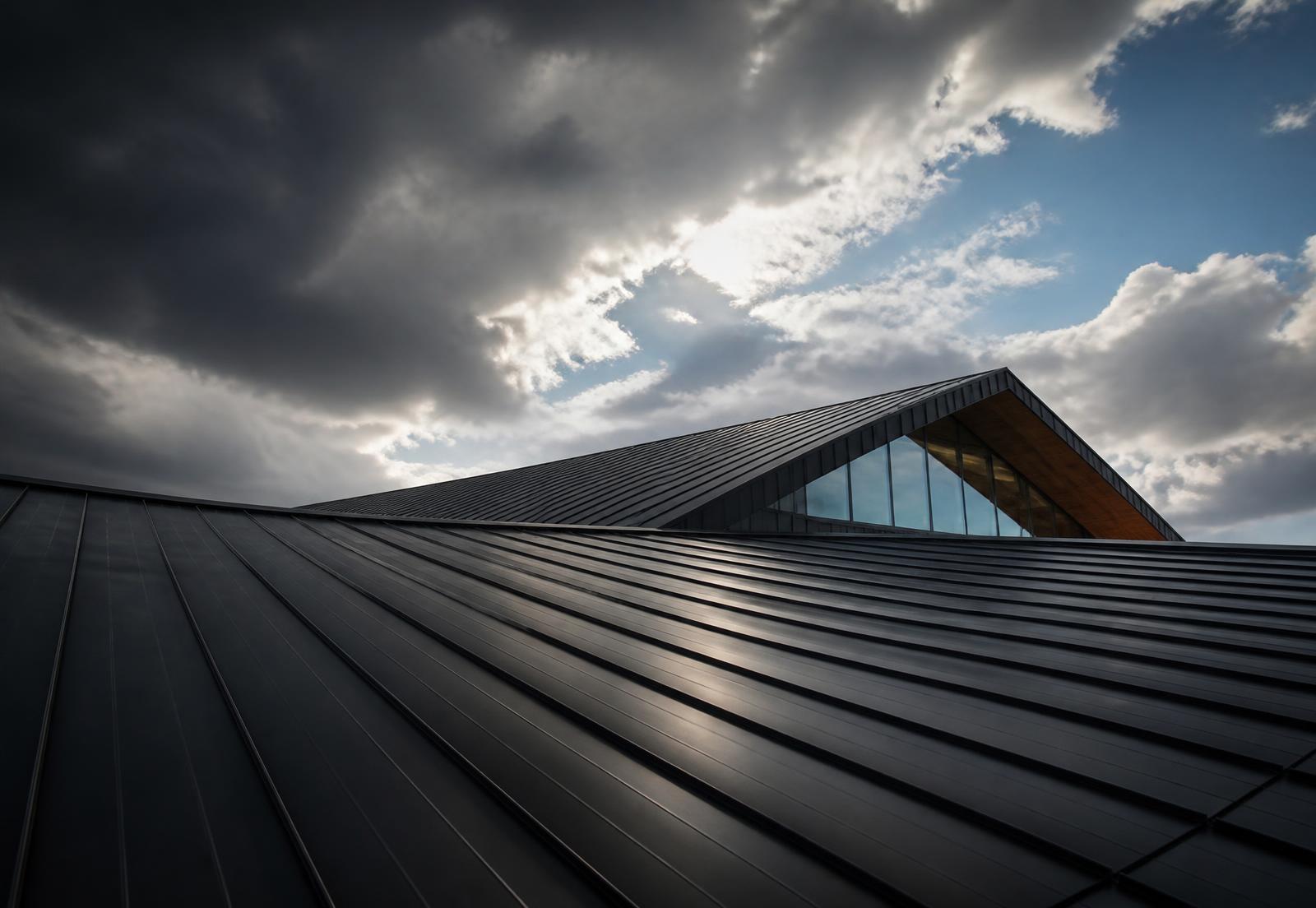 Matte black metal roof photographed from a low angle against a dramatic sky